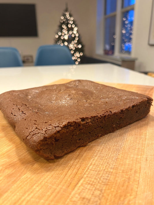 A slice of Crescent Bakes Fondant au Chocolat on wood board
