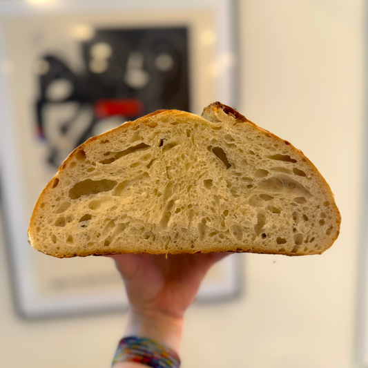 Hand holding a slice of bread with a blurred background