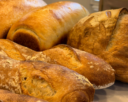 Assorted loaves of Crescent Bakes Sourdough Sandwich bread, Sourdough Baguette, and Sourdough loaf with a rustic appearance
