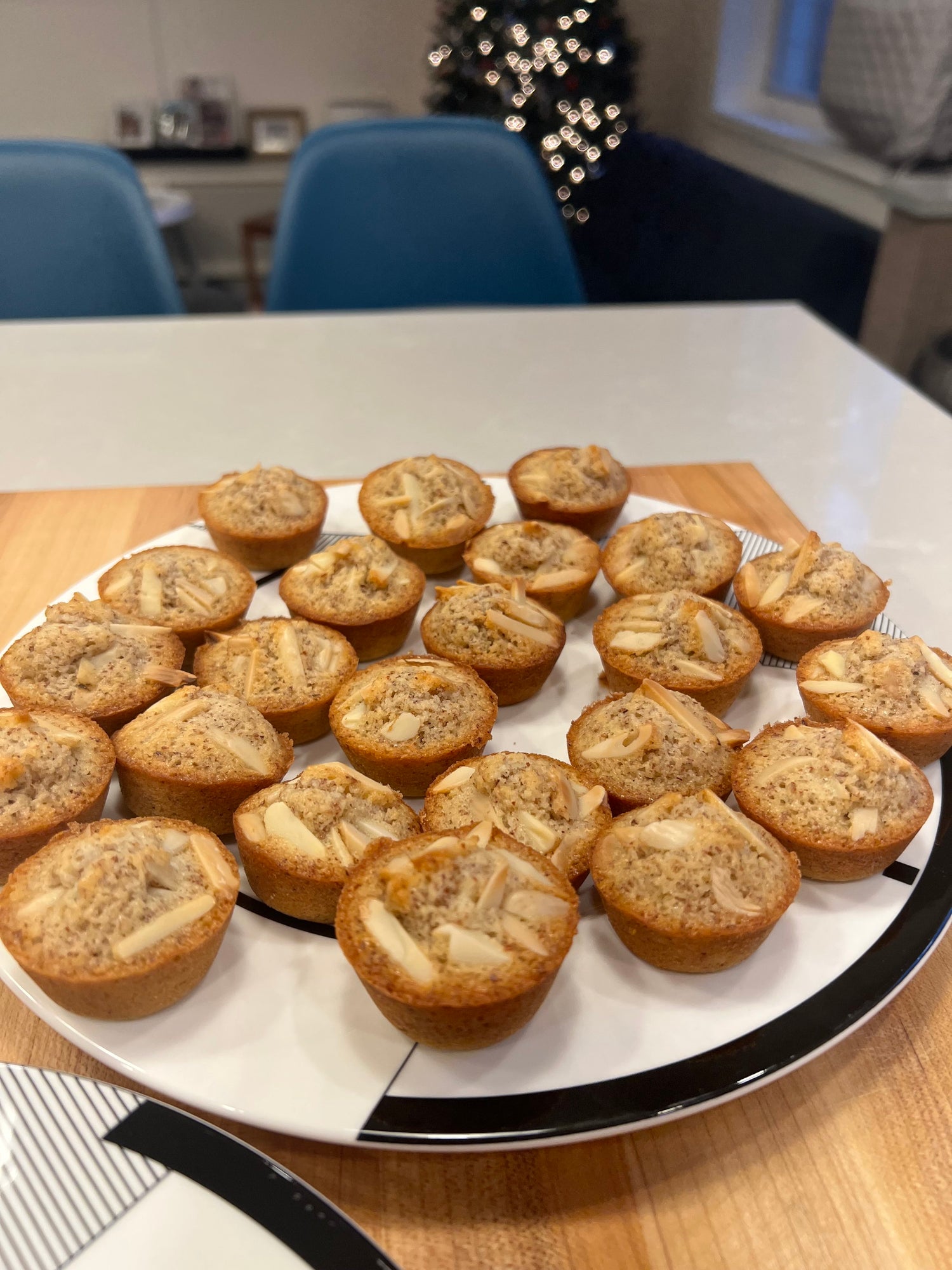 A plate of freshly baked Crescent Bakes almond financiers on a kitchen counter.