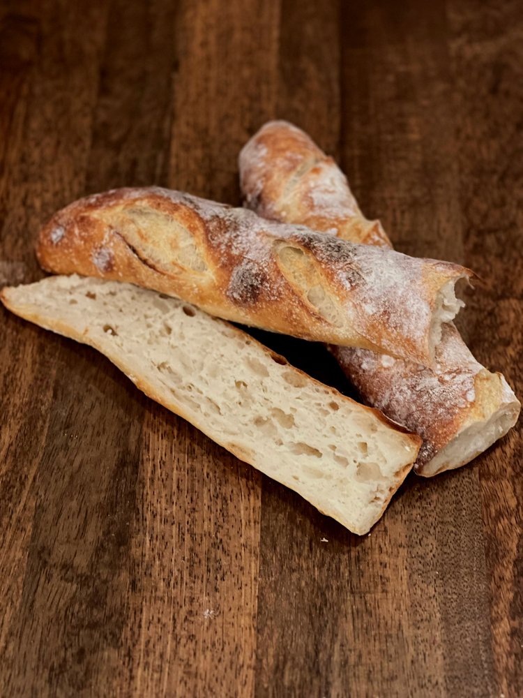 Crescent Bakes Sourdough Baguette sliced open resting on wood